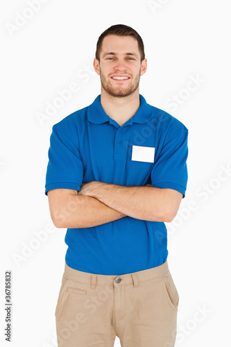Smiling young salesman with folded arms photo