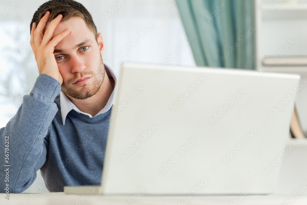 Businessman annoyed by notebook in his homeoffice Businessman annoyed by notebook in his homeoffice