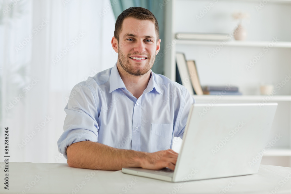 Businessman with rolled up sleeves on his laptop in his homeoffi Businessman with rolled up sleeves on his laptop in his homeoffi