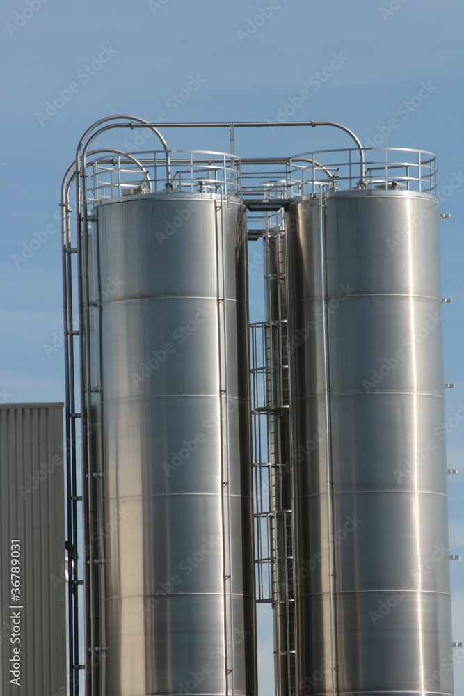 View of an industrial plant with large aluminum tanks View of an industrial plant with large aluminum tanks