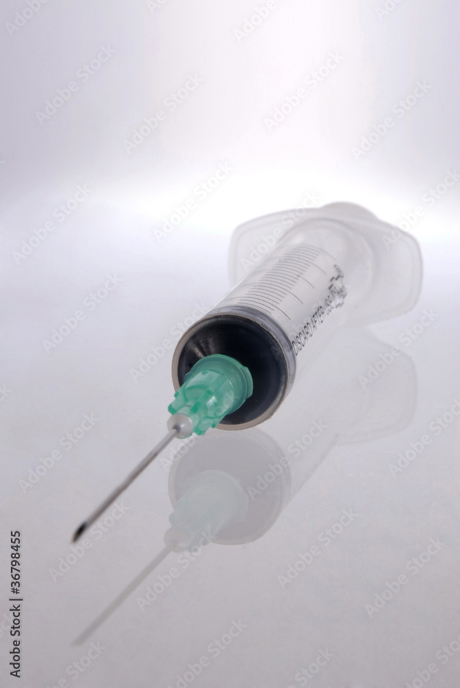 Syringe with reflection over clear background Syringe with reflection over clear background