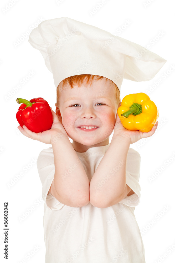 red-haired boy in cook hat with vegetables isolated on white red-haired boy in cook hat with vegetables isolated on white