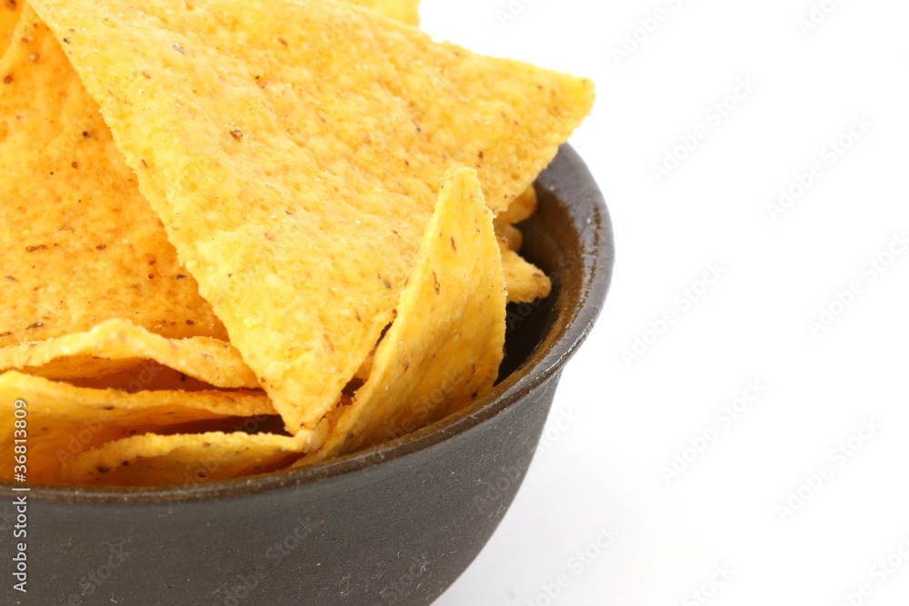Mexican tortilla chips in brown bowl on white background Mexican tortilla chips in brown bowl on white background