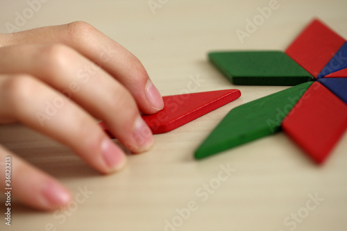 Final Piece. Child's hand, inserting missing piece of blank puzz photo