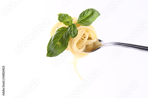 Spaghetti on a fork decorated with basil