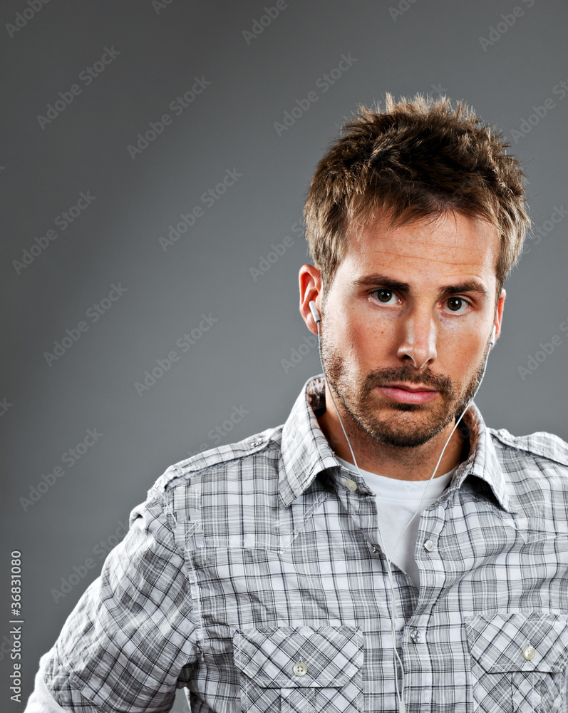 Obraz premium Serious young man listening to music