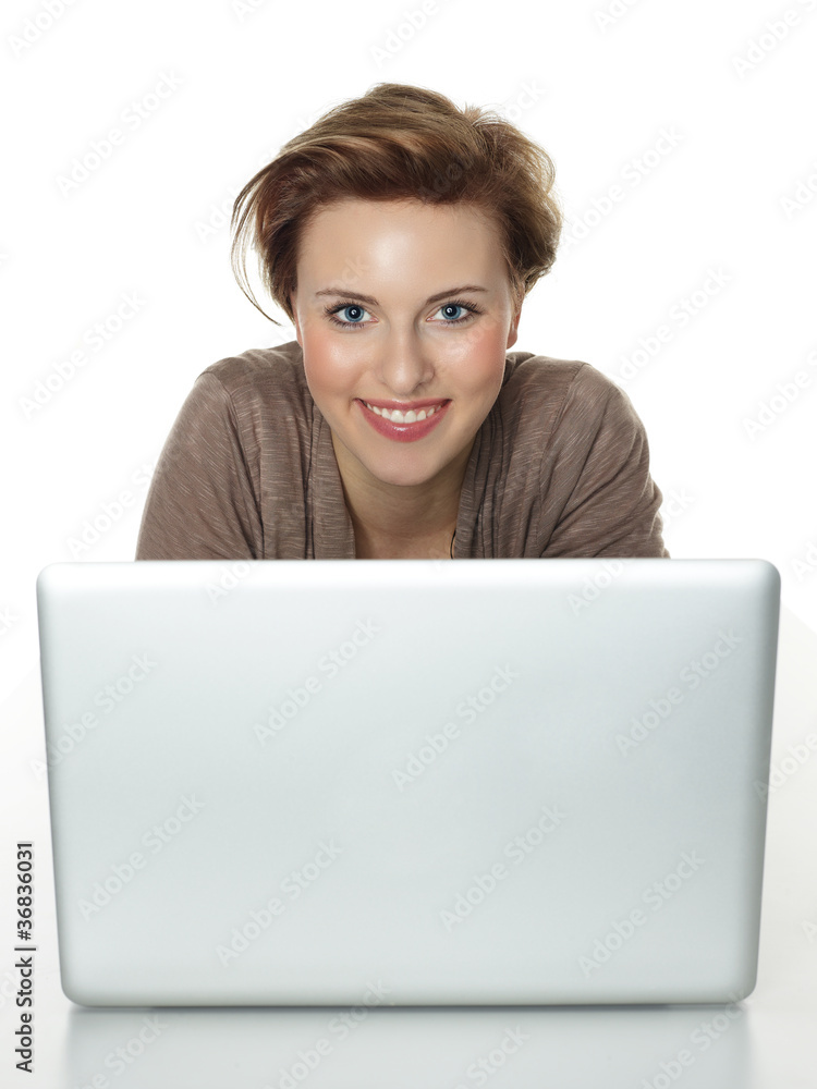 Naklejka premium Pretty woman behind her laptop surfing on the internet