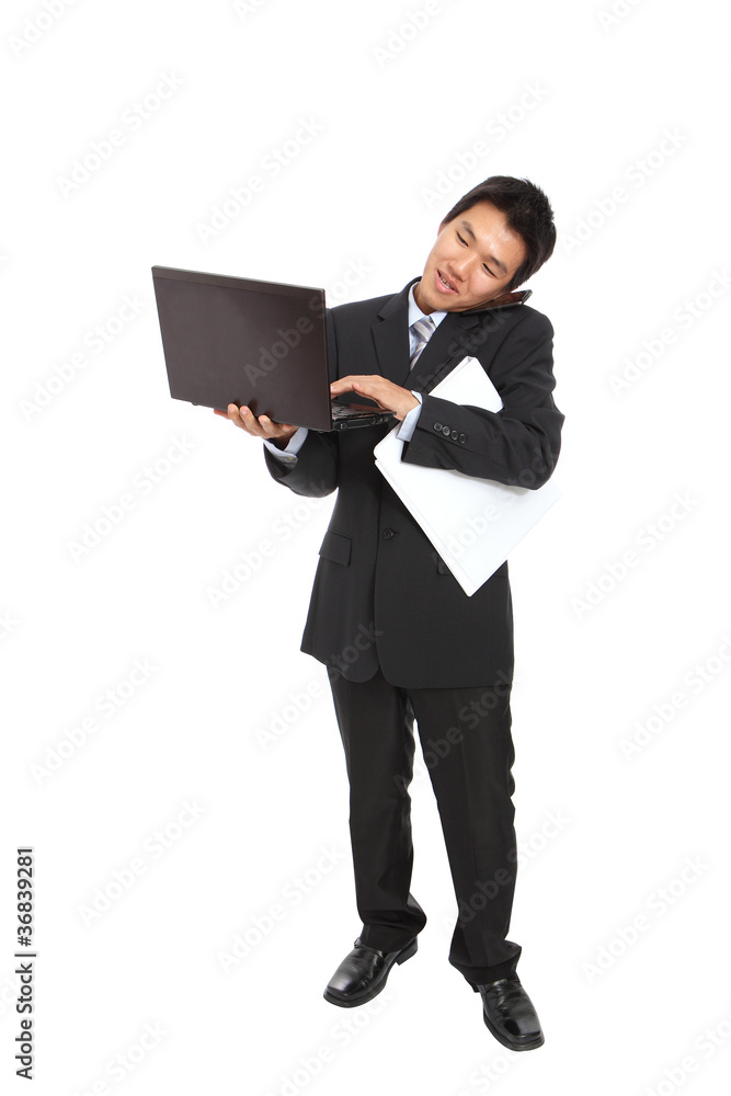 young business man using notebook and speaking mobile phone