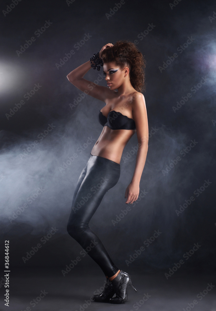 Young sexy brunette over black background with smoke Young sexy brunette over black background with smoke