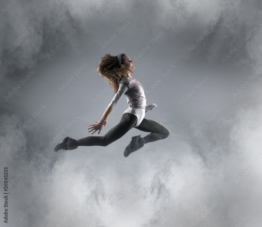 A young Caucasian female dancer caught in a jump