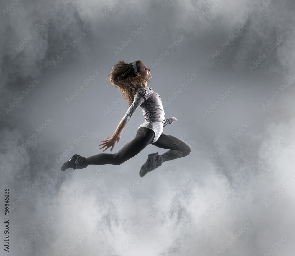 A young Caucasian female dancer caught in a jump A young Caucasian female dancer caught in a jump