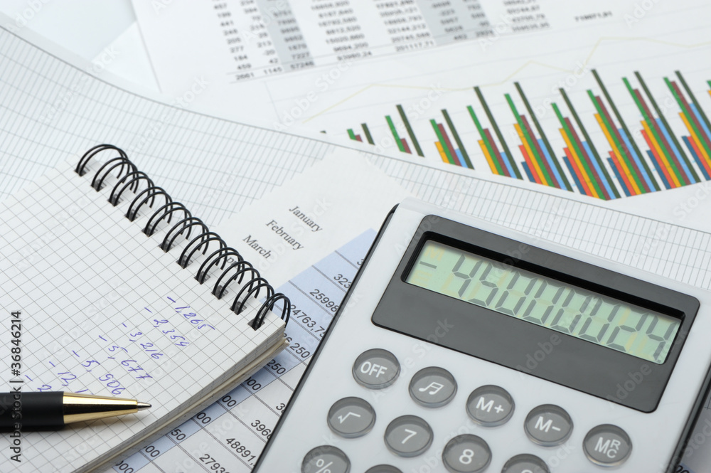 The calculator and the financial report blue toned The calculator and the financial report blue toned