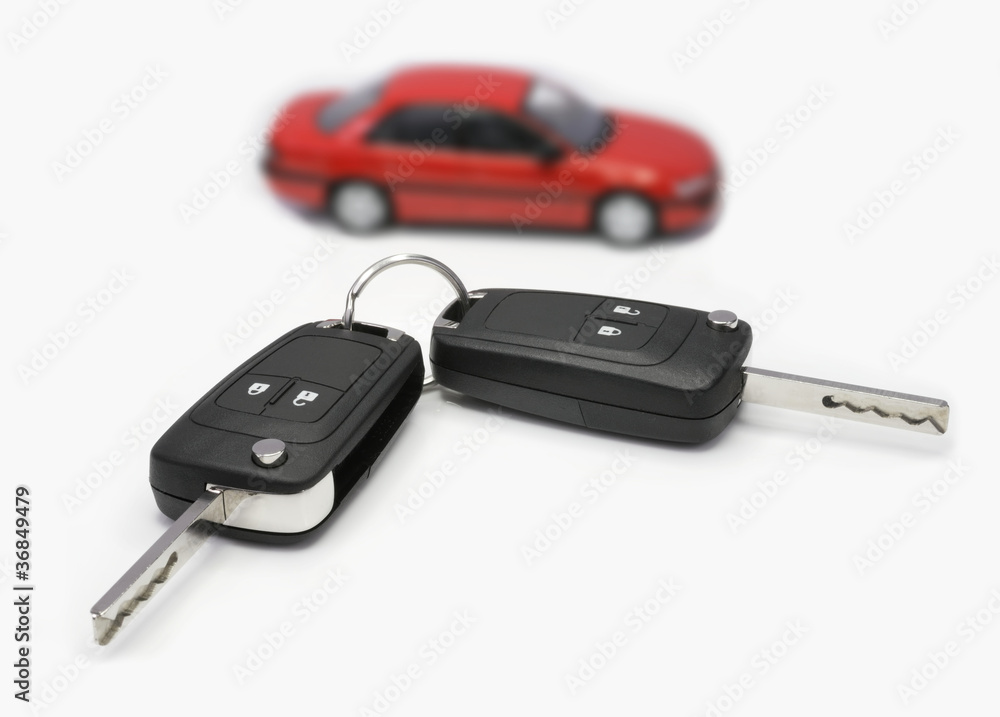 Zündschlüssel mit Auto im Hintergrund Zündschlüssel mit Auto im Hintergrund