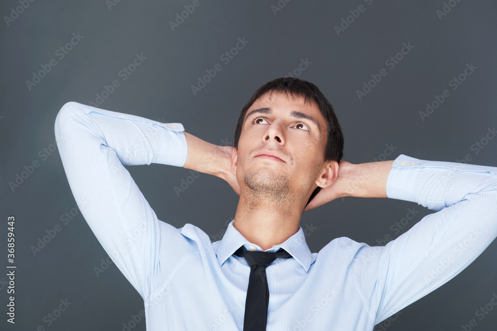 Portrait of relaxed business man against grey background. Daydre Portrait of relaxed business man against grey background. Daydre
