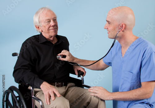 Doctor or nurse listening to elderly patients heart.