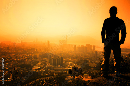 Photography Man standing on the edge of Hong Kong's Lion Peak