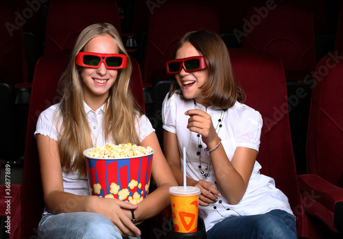 Two young girls watching in cinema