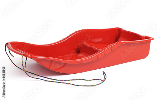 Plastic red sled for skiing on white background photo