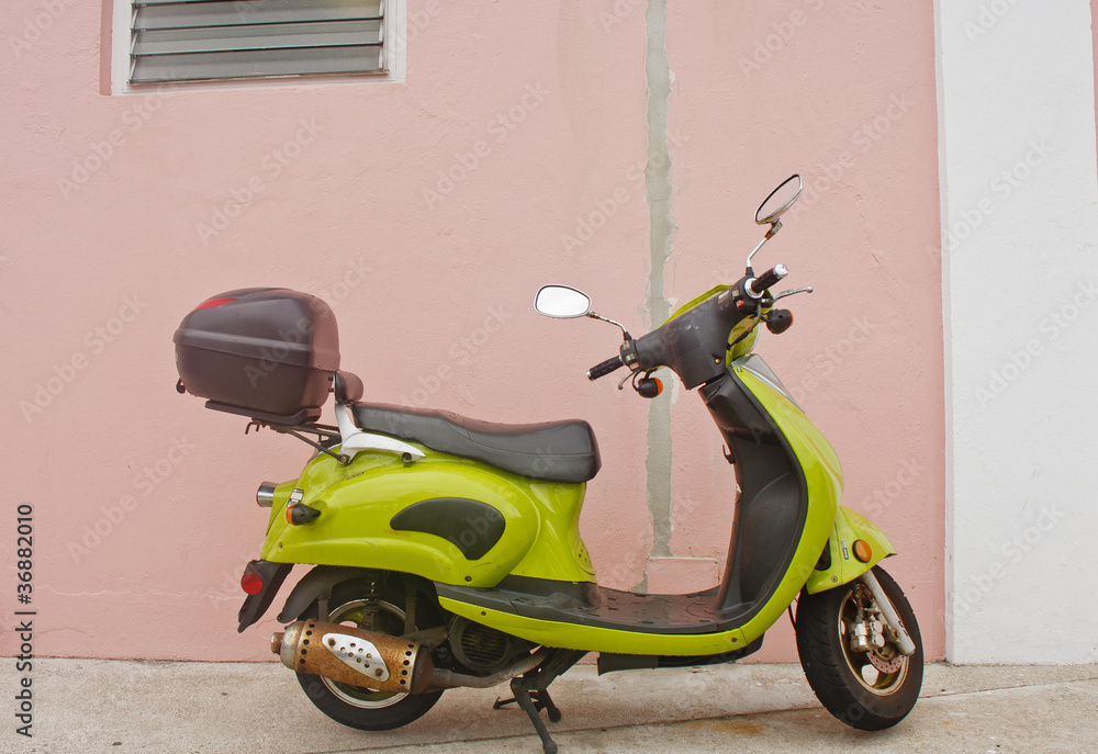 Green Scooter Against Pink Wall