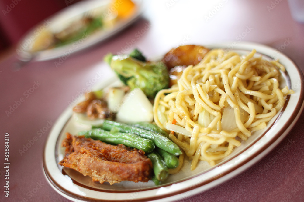 Chinese Chow mein with vegetables and sides.