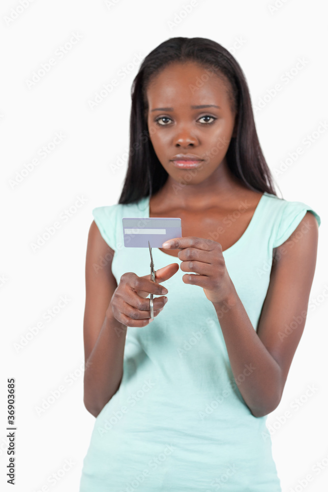 Sad woman cutting her credit card into pieces Sad woman cutting her credit card into pieces