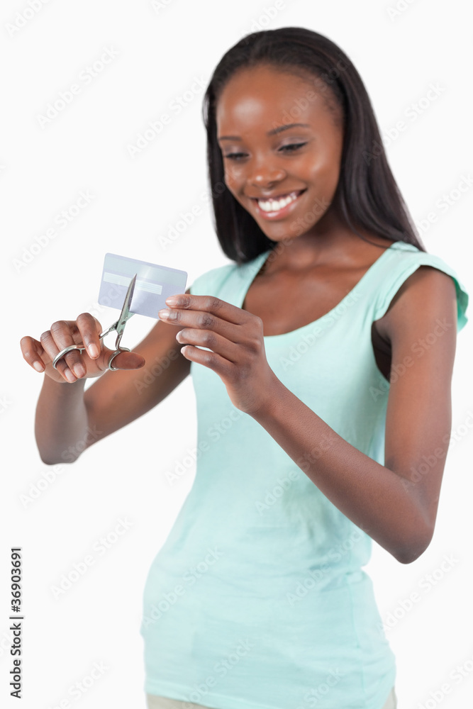 Smiling woman cutting her credit card into pieces Smiling woman cutting her credit card into pieces