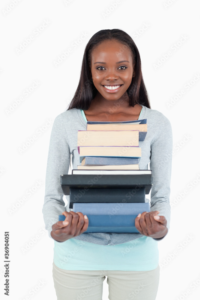 Smiling young woman with a pile of books Smiling young woman with a pile of books