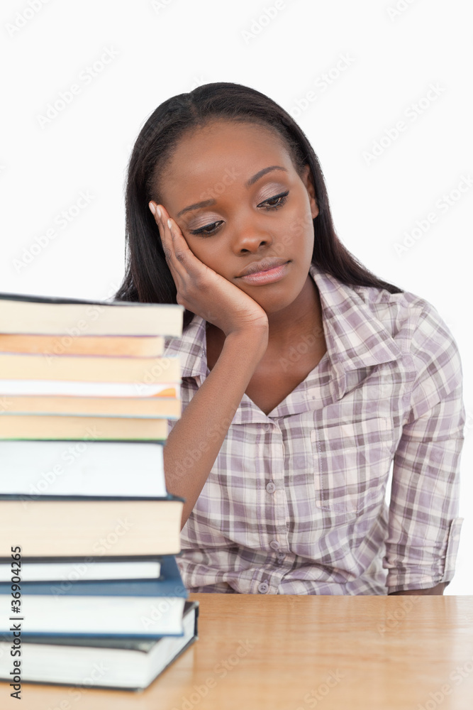 Young woman sitting behind table while daydreaming Young woman sitting behind table while daydreaming