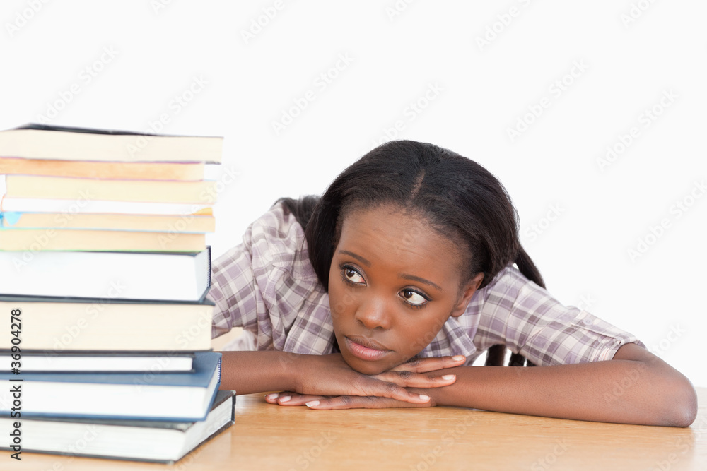 Student looking at a stack of books Student looking at a stack of books