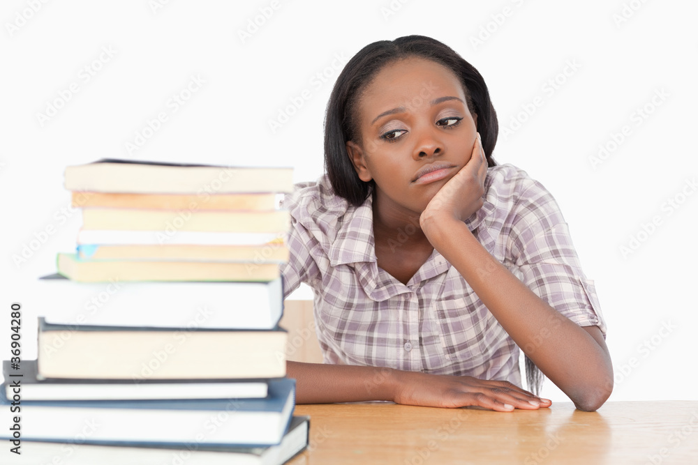 Bored student looking at a stack of books Bored student looking at a stack of books