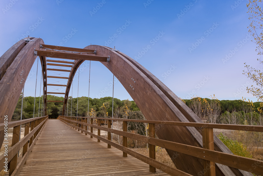 Arched wood bridge in forest
