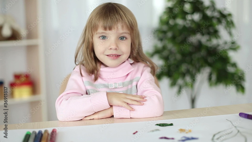 Girl with folded hands looking at camera Girl with folded hands looking at camera