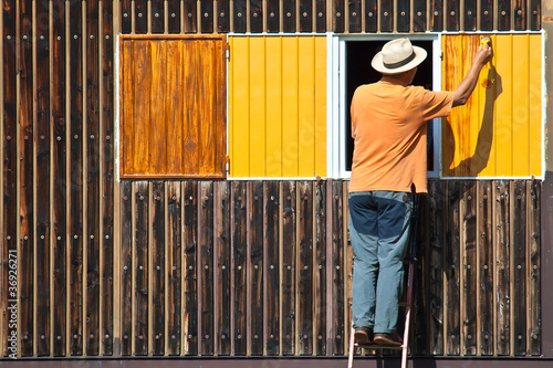 uomo pittura la parete di una casa photo