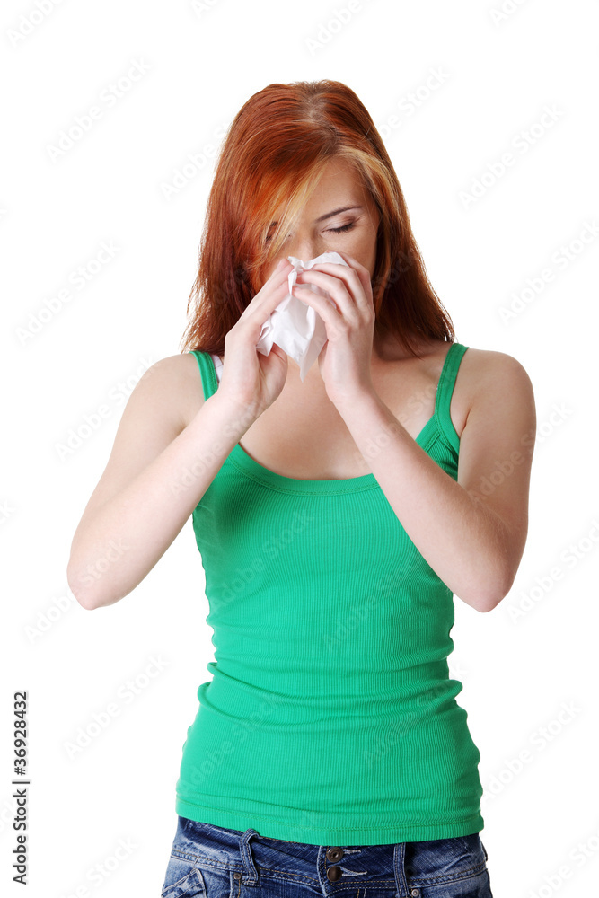 Teen girl blowing her nose. Teen girl blowing her nose.