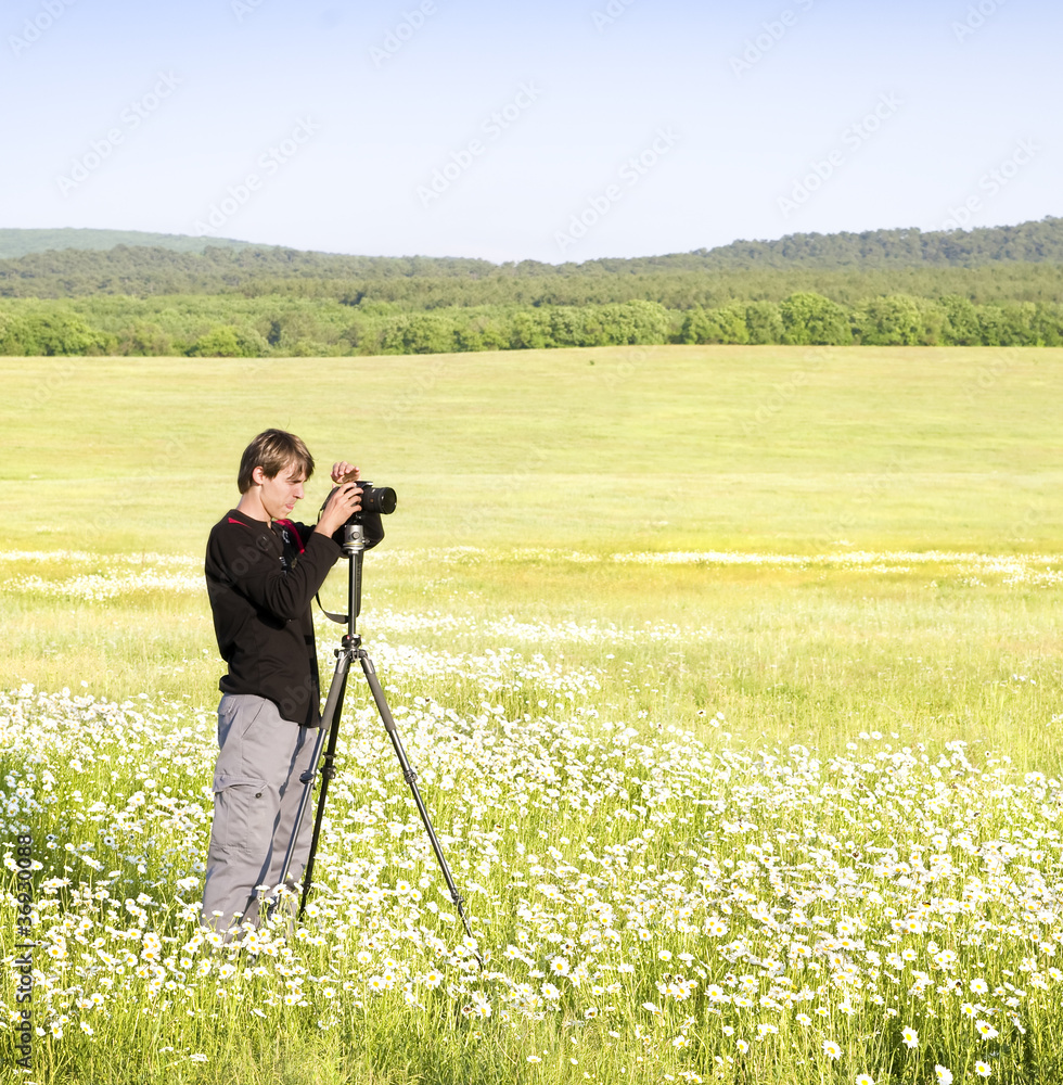 photographer with camera on meadow