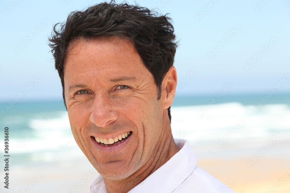 Man smiling at the seaside.