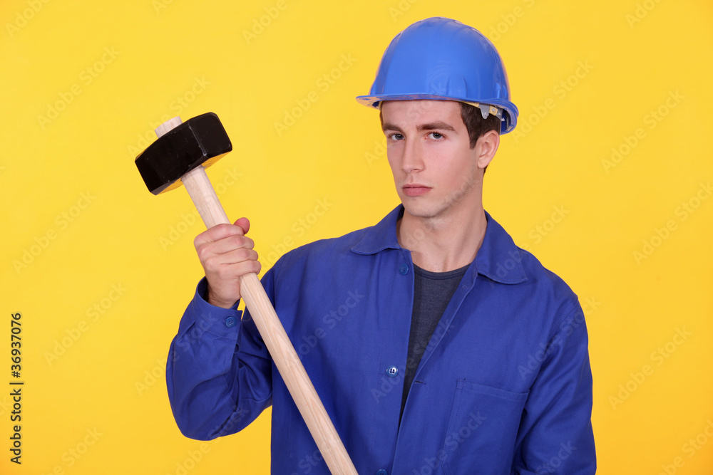 A manual worker with a sledgehammer. A manual worker with a sledgehammer.