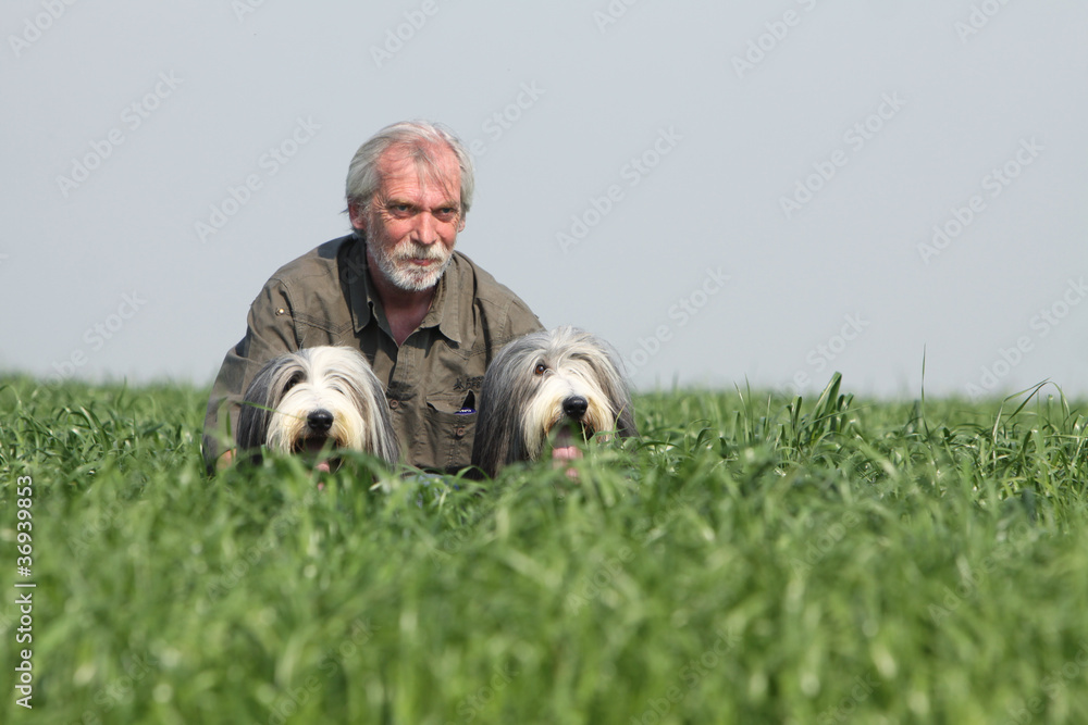 maitre accompagné de ses deux bearded collies