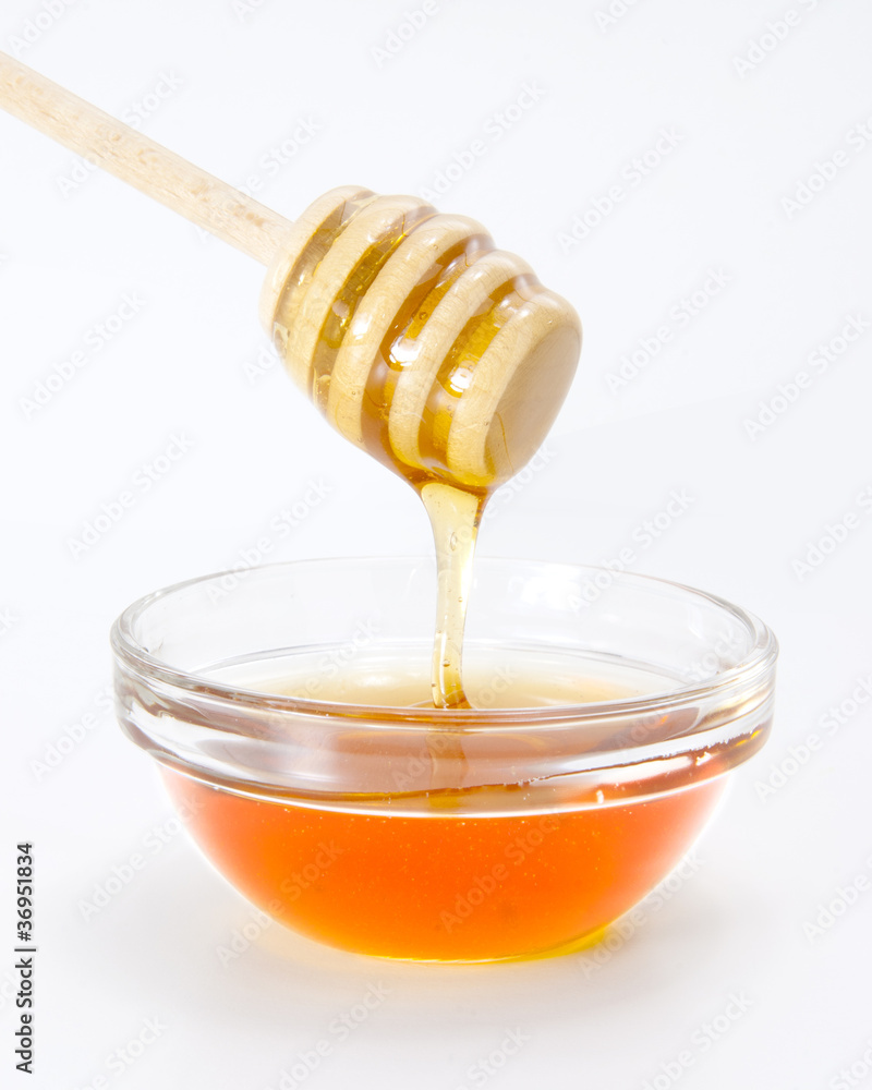 Honey in bowl with wood stick Honey in bowl with wood stick