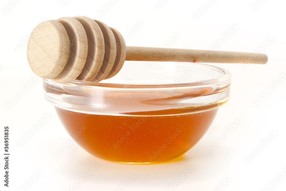 Honey in bowl with wood stick Honey in bowl with wood stick