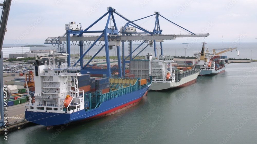 Freight ships loaded with cargo in front of wind farm Freight ships loaded with cargo in front of wind farm