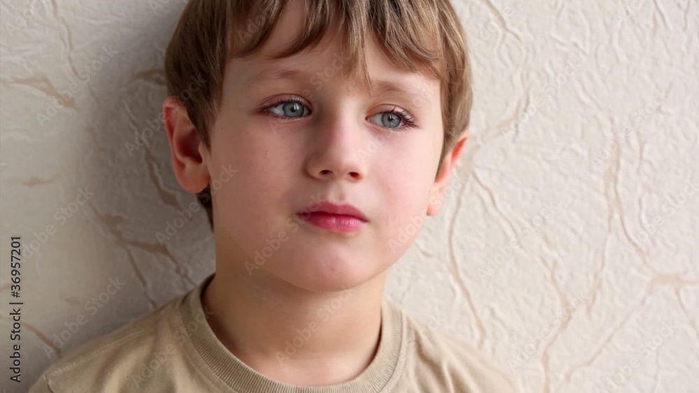 little boy face on background of wall covered with wallpaper little boy face on background of wall covered with wallpaper
