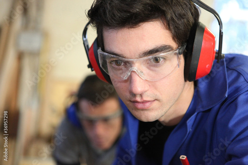 Φωτογραφία Closeup of a young worker wearing ear defenders