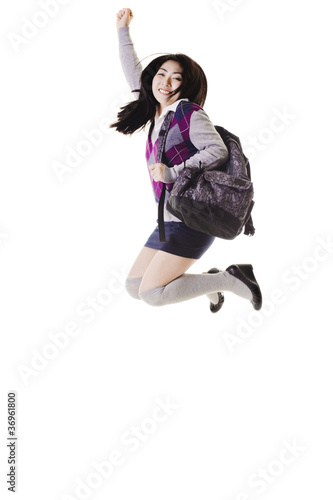 Chinese school girl jumping into air.