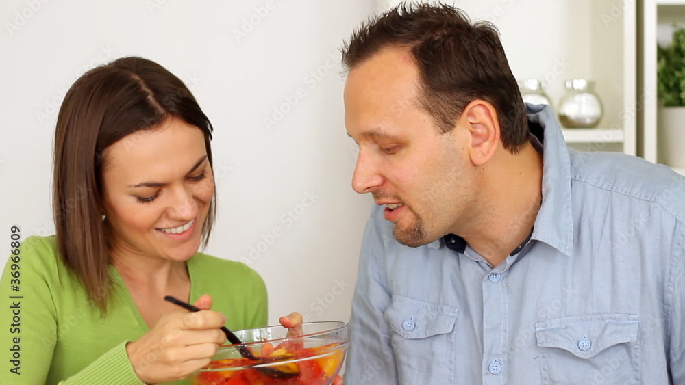 Young happy couple playfully feeding each other Young happy couple playfully feeding each other