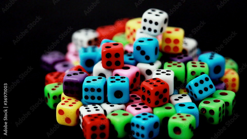 many colorful dice stacked in hill rotate on black, close-up many colorful dice stacked in hill rotate on black, close-up