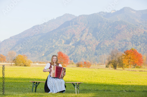 Bergpanorama im Herbst mit Akkordeonspielerin photo