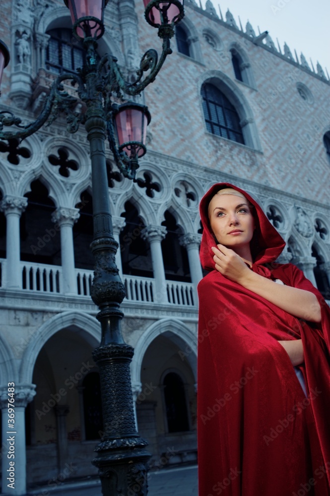Beautifiul woman in red cloak against Dodge's Palace