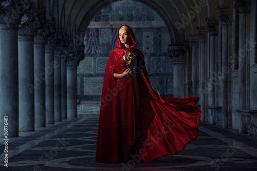 Beautifiul woman in red cloak outdoors