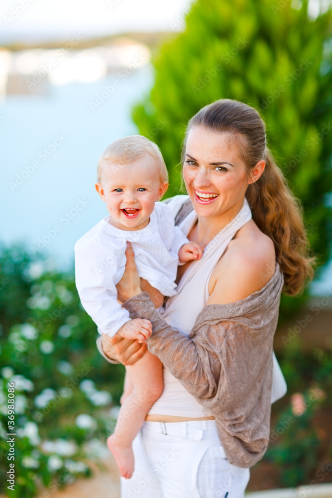 Portrait of beautiful mother with cute little baby on street Portrait of beautiful mother with cute little baby on street